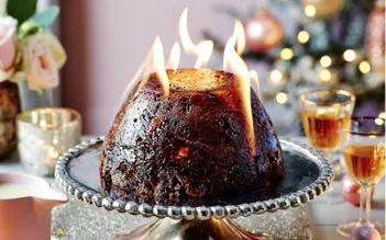 Christmas pudding põe fogo na mesa de Natal